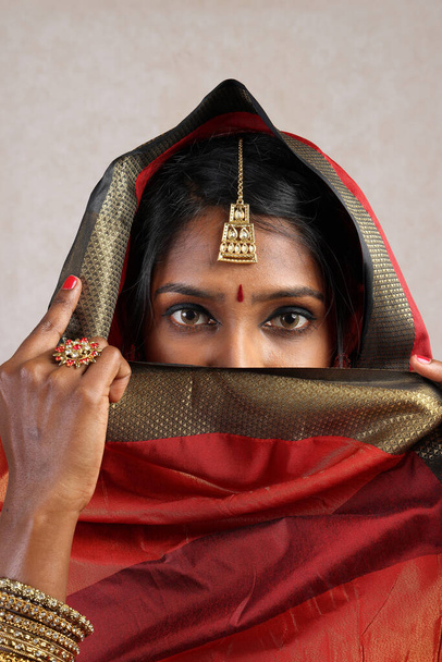 Indian woman wearing red orange saree jewellery choker set necklace jhumka earring maang tikka waist chain stand pose look see smile mood expression head cover hijab   - Φωτογραφία, εικόνα
