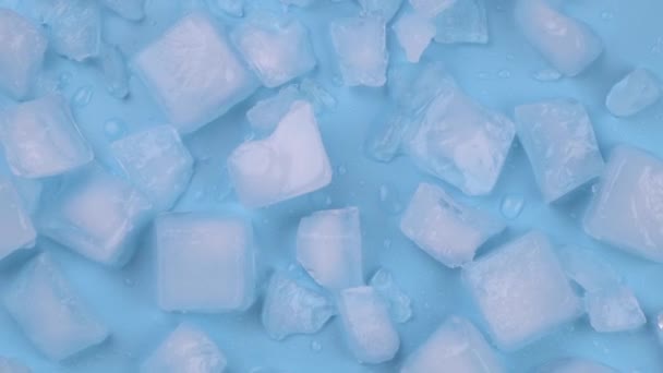 Fundo azul rotativo com cubos de gelo e gotas de água. Imagens 4k de alta qualidade - Filmagem, Vídeo