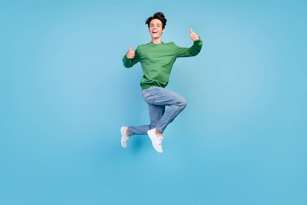 Full length body size photo guy jumping up showing thumb-up isolated pastel blue color background. - Foto, imagen
