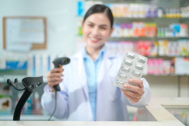 A Female pharmacist scanning barcode on a medicine box in a modern pharmacy drugstore. - Фото, зображення