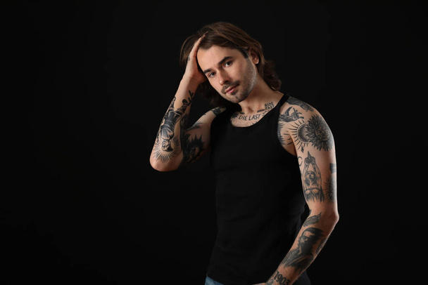 Young man with tattoos on body against black background - Fotoğraf, Görsel