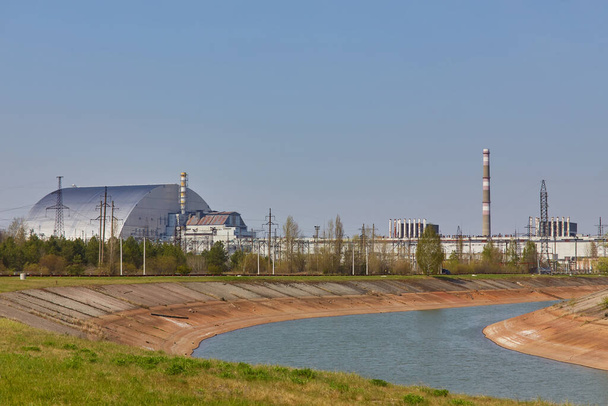 reaktory jądrowe elektrowni w Czarnobylu obok rzeki Prypeć, czwarty eksplodował reaktor z sarkofagiem po lewej stronie, trzeci reaktor po prawej, strefa wyłączenia, Ukraina, Europa Wschodnia - Zdjęcie, obraz