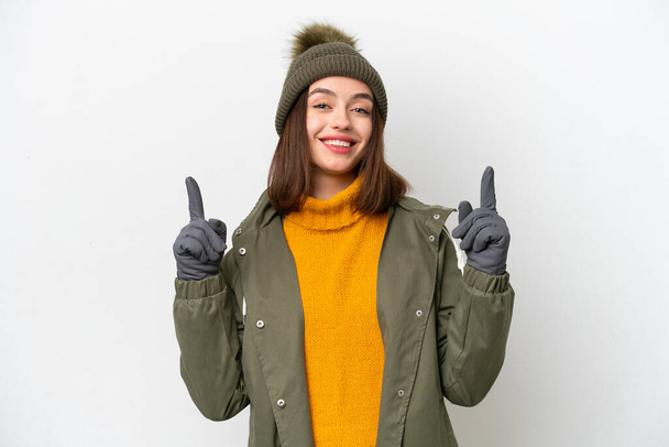 若いですウクライナの女性を身に着けている冬のジャケットは素晴らしいアイデアを指して白い背景に隔離 - 写真・画像
