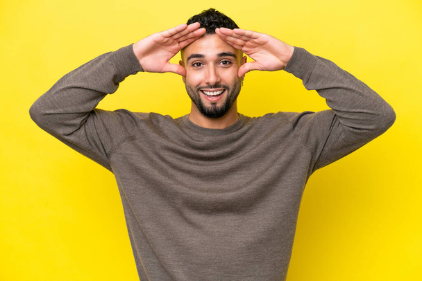 Young Arab handsome man isolated on yellow background with surprise expression - Foto, imagen