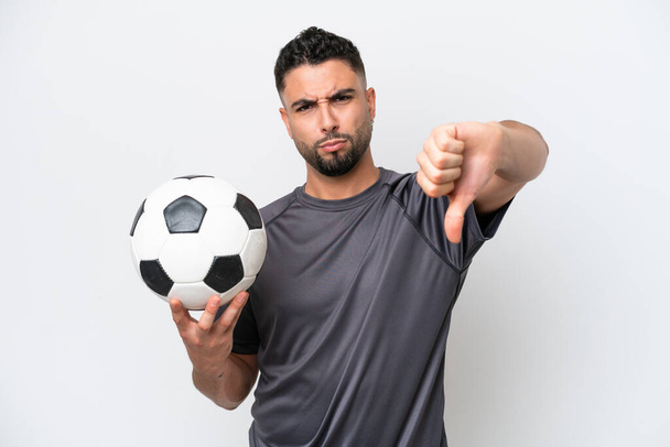 Arab młody piłkarz człowiek izolowany na białym tle pokazuje kciuk w dół z negatywnym wyrazem - Zdjęcie, obraz