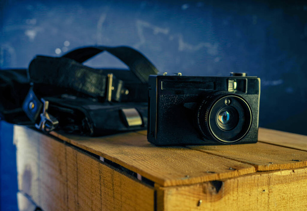 Film camera and beautiful lens flare. Vintage photo with an old camera. Camera and bag. Front view. - Photo, Image