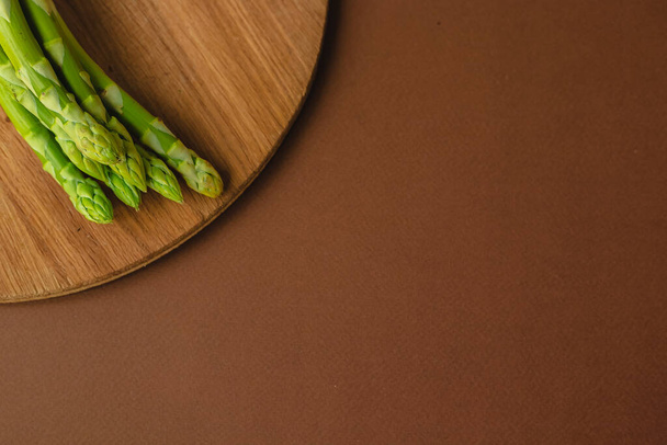 takken van verse groene asperges op een houten achtergrond, bovenaanzicht - Foto, afbeelding