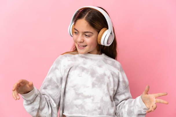 Bambino su sfondo rosa isolato ascoltare musica e ballare - Foto, immagini