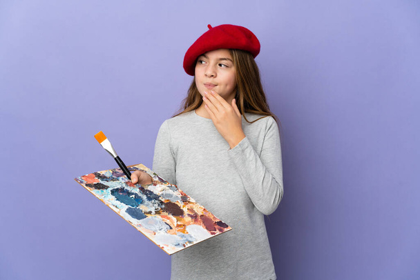 Artist girl over isolated background looking up while smiling - Valokuva, kuva