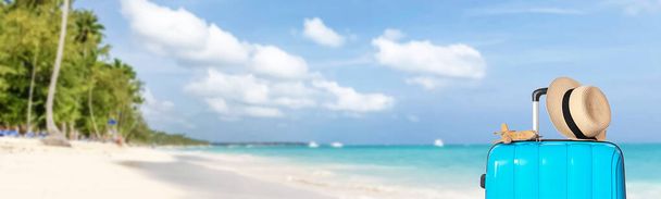 Vol toeristische koffer, speelgoed vliegtuig en hoed op zee strand. Banner voor ontwerp - Foto, afbeelding