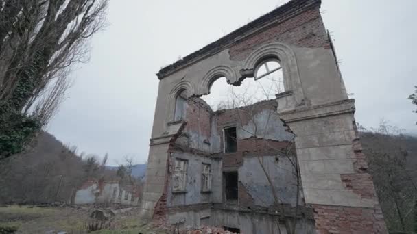 Ruined old building in forest. Action. View of ruined walls of brick building on background of forest. Destroyed houses in gloomy overcast forest.  - Footage, Video