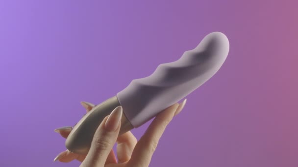 Mujer sostiene juguete sexual. Creativo. Womans mano sostiene juguetes sexuales vaginales. Vibrador para la satisfacción femenina. Tipos modernos de vibradores y juguetes sexuales.  - Metraje, vídeo