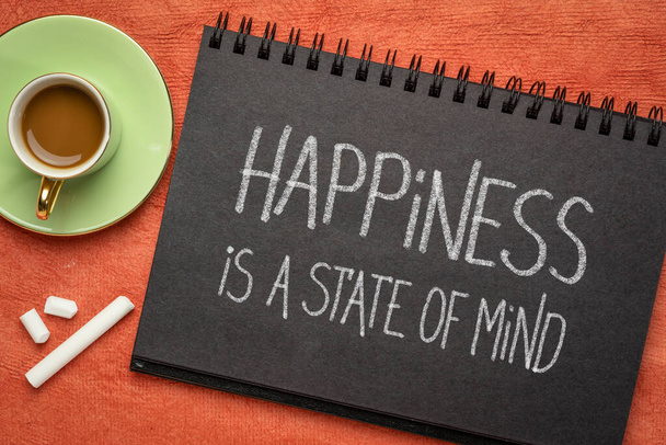 happiness is a state of mind inspirational reminder - white chalk handwriting in a black paper sketchbook with a cup of coffee, personal development, mindset and attitude concept - Photo, Image