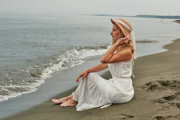 дивовижна дівчина дивиться на море в білій сукні. Високоякісна фотографія
 - Фото, зображення