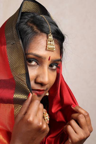 Индийская женщина в красно-оранжевом сари ювелирные украшения choker набор ожерелье jhumka серьга Maang tikka талии цепи стоять позе смотреть на улыбку выражение лица настроение хиджаб   - Фото, изображение