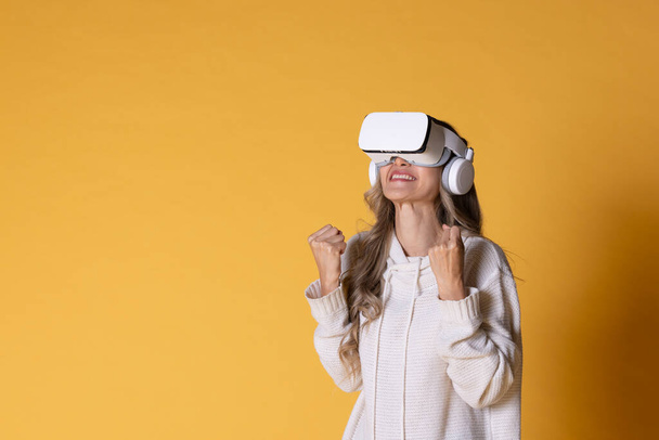 İnteraktif sanal gerçeklik gözlüksüz. VR ya da Sanal Gerçeklik başlığı takan genç kadın öğrenmek, seyahat etmek ya da oyun oynamak için dijital simülasyon dünyasına girmeye hazır.. - Fotoğraf, Görsel