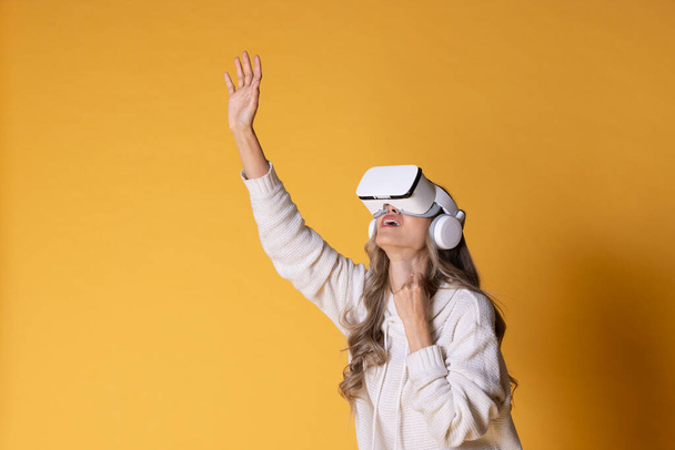 Interactive virtual reality goggles.Asian teen woman wearing VR or Virtual Reality head set for enter to the digital simulation world for learning and traveling or gaming and more. - Foto, Bild