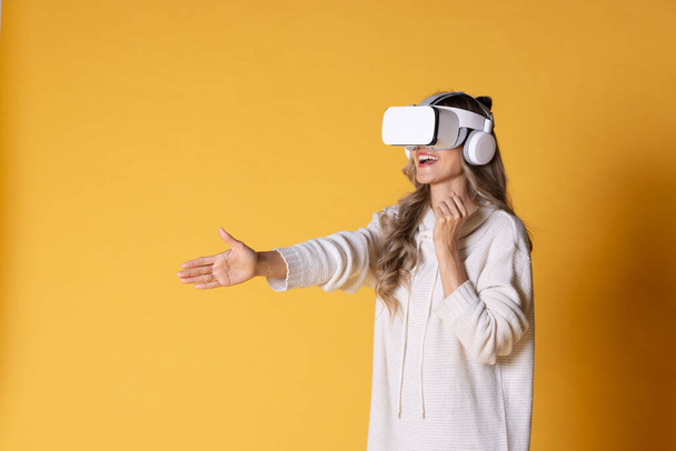 Interactive virtual reality goggles.Asian teen woman wearing VR or Virtual Reality head set for enter to the digital simulation world for learning and traveling or gaming and more. - Photo, Image