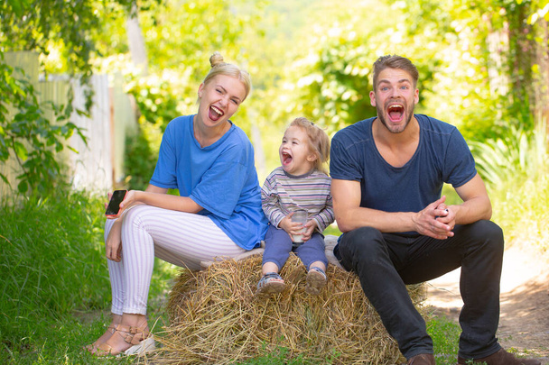 Happy young family of three having fun together launching. Cheerful funny parents playing with son outdoor. Father mother and child playing together - Φωτογραφία, εικόνα