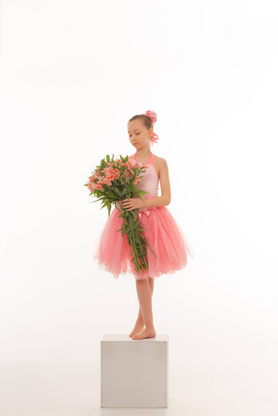 Girl ballerina with flowers in a tutu on a white isolated background - Фото, изображение