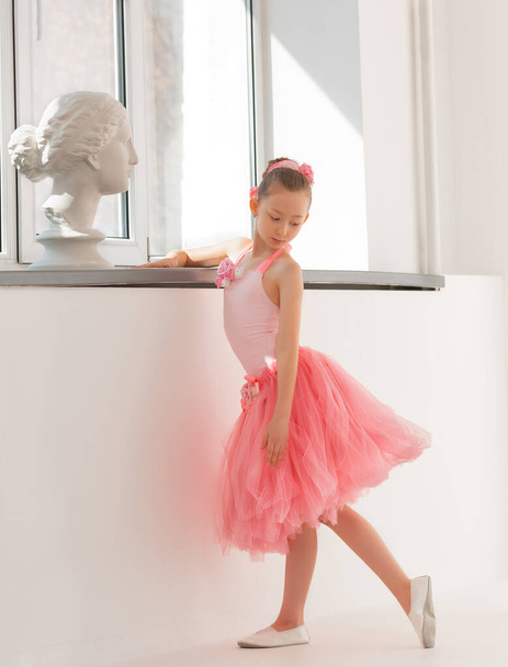 Girl ballerina in a tutu by the window with a statue of Venus - Фото, изображение