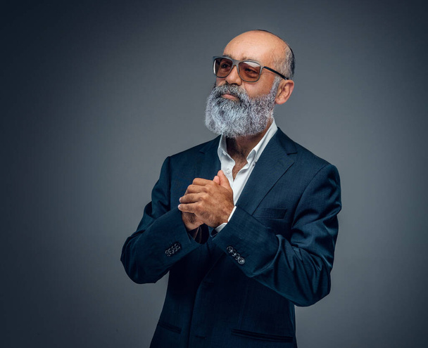 Aufnahme eines älteren Geschäftsmannes mit Bart und Sonnenbrille im schicken Anzug. - Foto, Bild