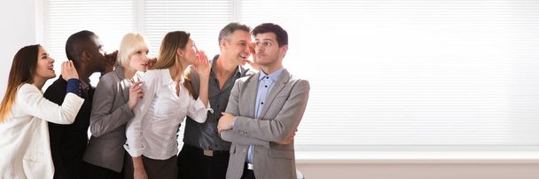 Business Colleague Whispering Secret Gossip To An Amazed Shocked Man With Wide Open Mouth - Fotoğraf, Görsel
