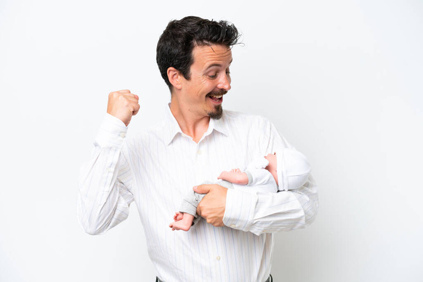 Молодий чоловік зі своєю новонародженою дитиною святкує перемогу
 - Фото, зображення