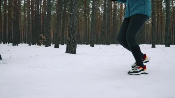biegacza w kolorowych trenerów i legginsy jogging na śniegu drogowego w zimie sportowca sprinting szybki trening cardio dla sprawności i zdrowia w lesie na świeżym powietrzu sport aktywny styl życia - Materiał filmowy, wideo