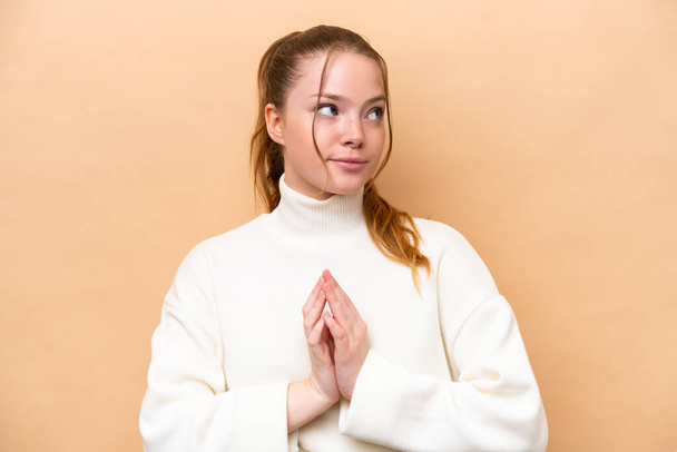 Young caucasian woman isolated on beige background scheming something - Photo, Image