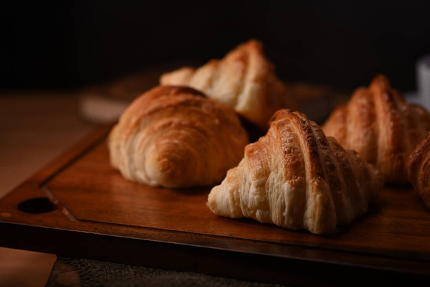 Croissants de mantequilla sobre tabla de madera para el desayuno. Levitación, productos de panadería concepto de cafetería. - Foto, imagen