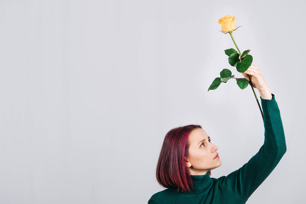 Mental health, wellness, wellbeing, world mental health day, think positive concept. Woman with one yellow rose flower in hand on light background. - Fotó, kép