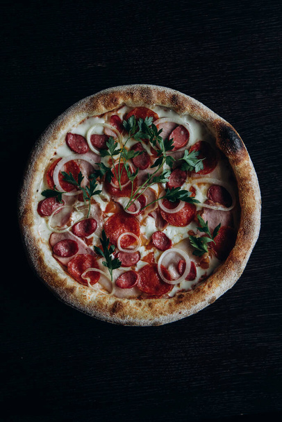 Oranje vers met duindoorn in een geslepen glas en pizza van een plakje en pizza - Foto, afbeelding