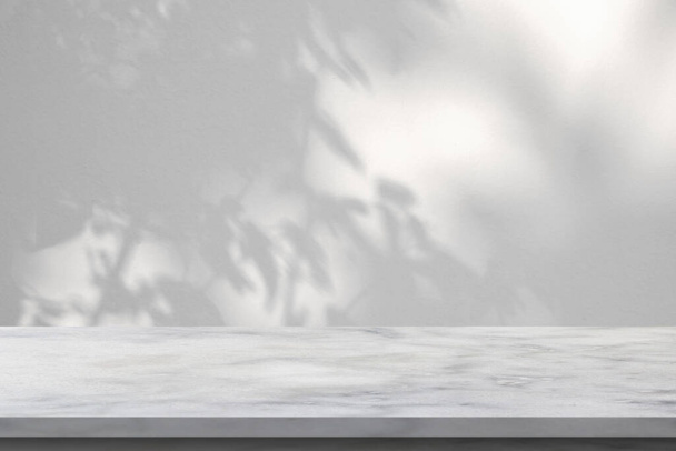 Marmeren tafel met boom schaduw laten vallen op witte muur achtergrond voor mockup product display - Foto, afbeelding