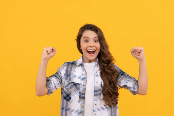 happy teen kid in checkered shirt with long curly hair on yellow background. - 写真・画像