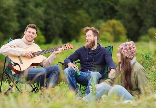 group of tourists playing guitar in camping - Foto, Bild