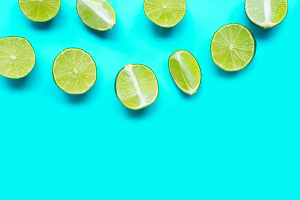 Fresh limes on blue background. top view - Zdjęcie, obraz