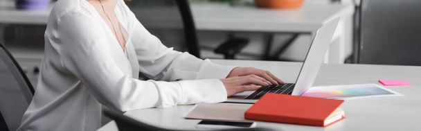 partial view of woman typing on laptop in advertising agency, banner - Fotó, kép