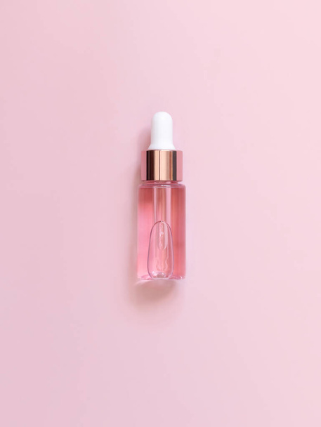 Pink Dropper Bottle on light pink, top view, mockup. Skin care beauty product, Aromatic oil or serum. Homemade cosmetics, pastel minimal compositio - Photo, Image