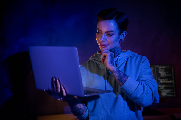Foto von gleichgesinnten attraktiven Web-Designerin Dame halten Verwendung drahtlosen Netbook Arm berühren Kinn dunklen Büroraum drinnen. - Foto, Bild