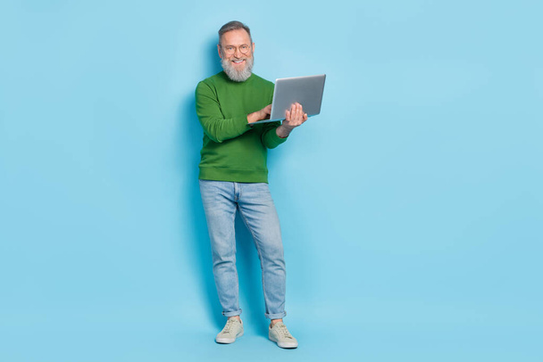 Full body photo of smart ceo aged man use netbook communication wear denim sweater isolated blue color background. - Photo, image