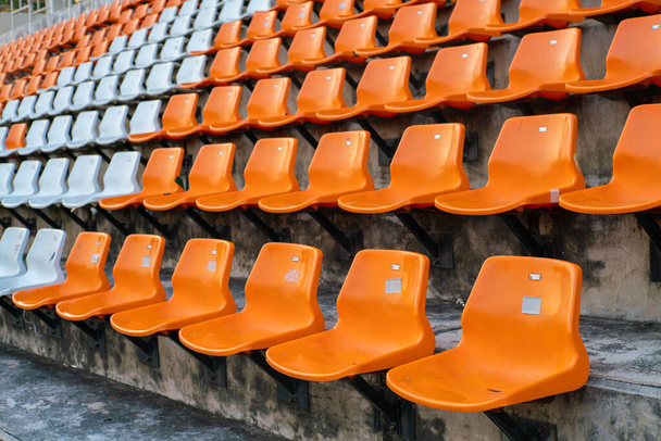Orangefarbene und weiße Stadien Amphitheater leere Plastiksitze - Foto, Bild