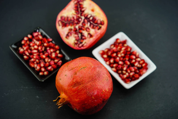 aufgeschnittener roter Granatapfel auf einer Schiefertafel - Foto, Bild
