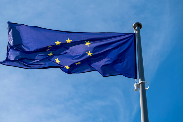 Drapeau de l'Union européenne agitant le vent contre un ciel bleu clair. - Photo, image