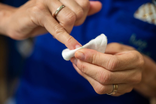 Detailní pohled na ženu čistící lak na nehty z nehtů s bavlněnou podložkou. - Fotografie, Obrázek