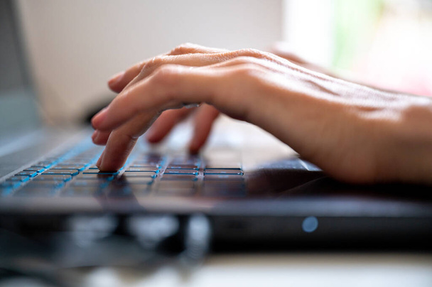 Low angle view of female fingers typing on laptop computer keyboard. - Photo, Image