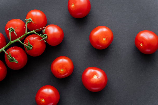 Top view of fresh red cherry tomatoes on black background  - 写真・画像
