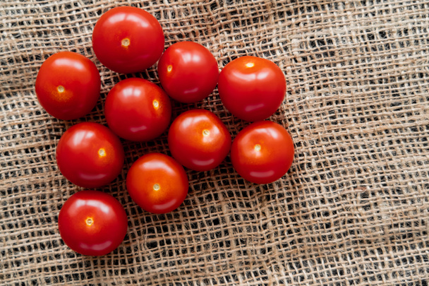 Vista superior de tomates cereja frescos em pano de saco  - Foto, Imagem
