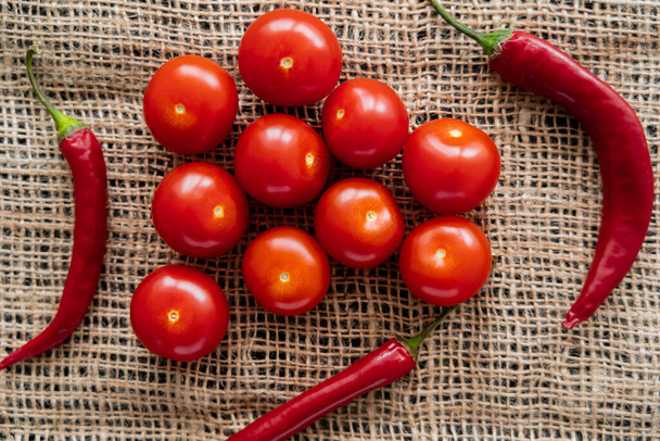 Vista superior de pimentas e tomates cereja em pano de saco  - Foto, Imagem