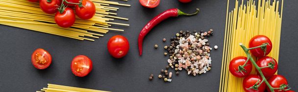 Flay lay with natural vegetables with uncooked pasta and spices on black background, banner  - Фото, зображення